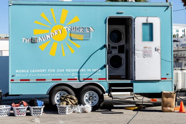 A laundry trailer is parked in front of a building.