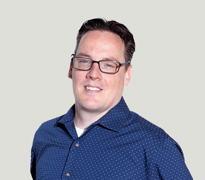 A man wearing glasses and a polka dot shirt.